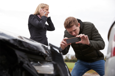 Conducteur prenant des photos de la voiture accidentée